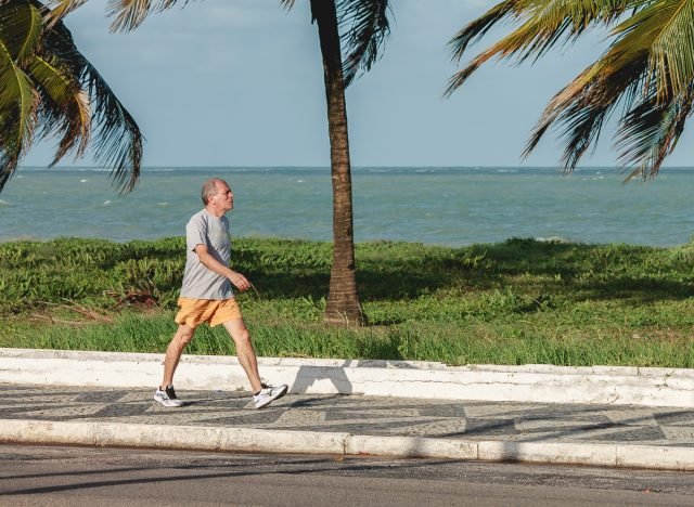 homme marchant, faire de l'exercice à l'extérieur près d'une plage tropicale