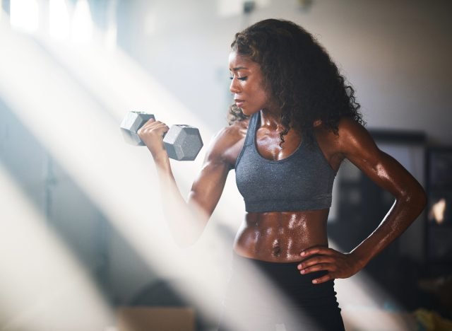 femme soulevant des haltères, concept de conseils de remise en forme pour les femmes afin de prévenir la perte musculaire