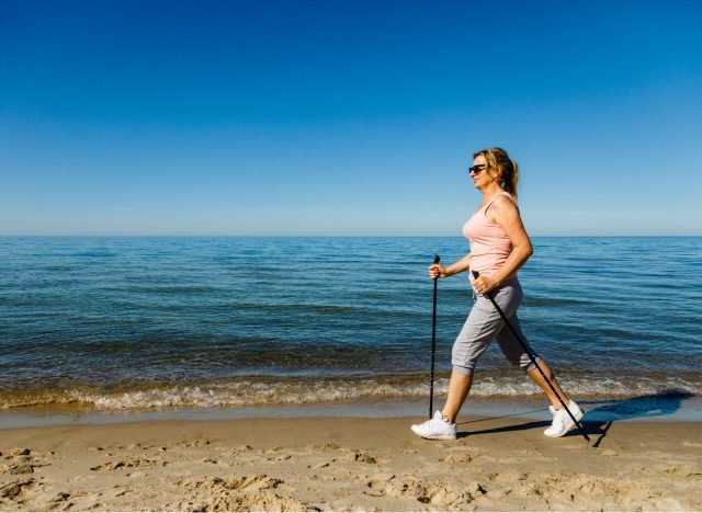 femme marchant sur une plage de sable faisant de l'exercice