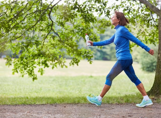 femme mûre en marche rapide sur les sentiers, concept d'exercices à faible impact pour faire fondre la graisse du ventre