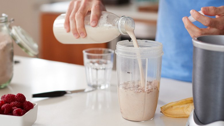 homme mélangeant de l'avoine et des baies dans un shake protéiné