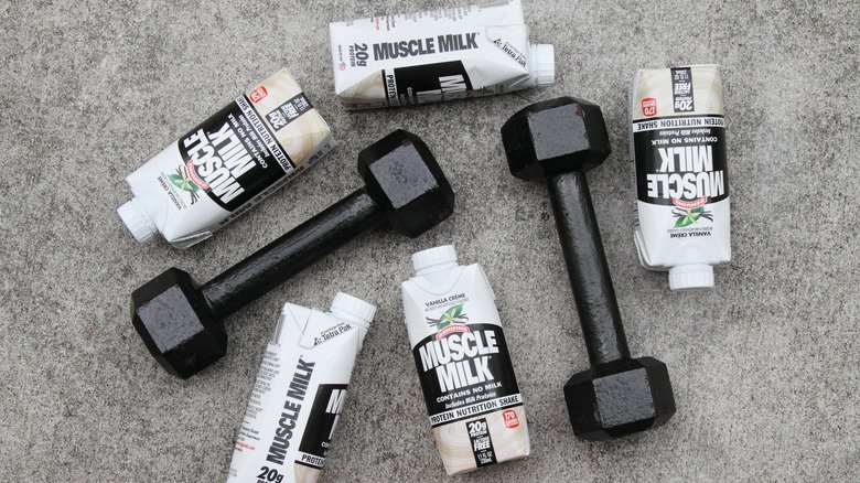 bouteilles de Muscle Milk prêtes à boire entourées de petits haltères