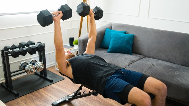 homme faisant du développé couché avec haltères