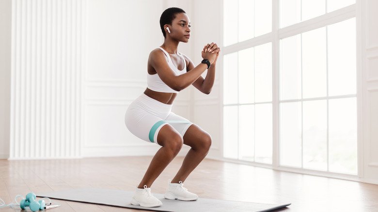 Femme faisant des squats sur un tapis