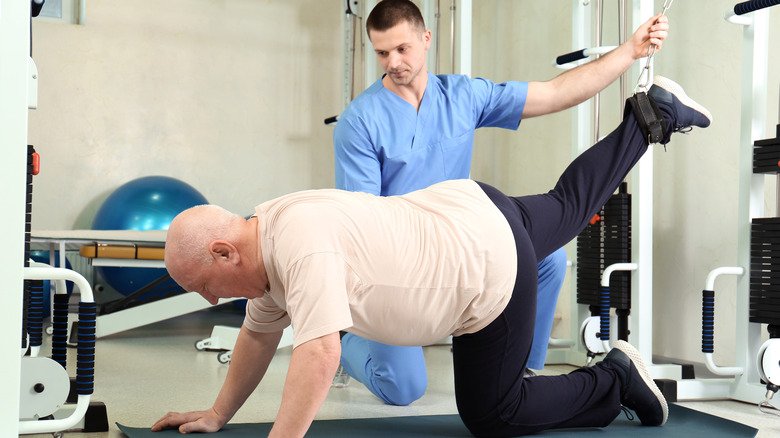 Homme âgé travaillant avec un physiothérapeute