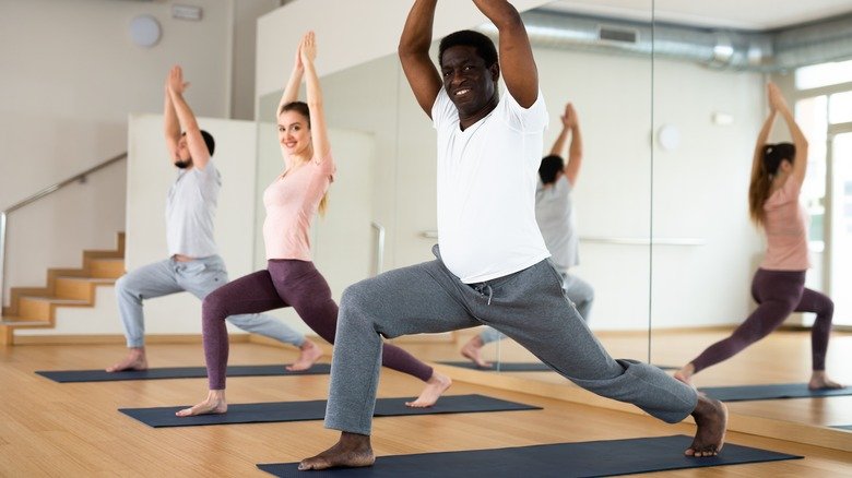 cours de yoga diversifié faisant la pose du guerrier 1