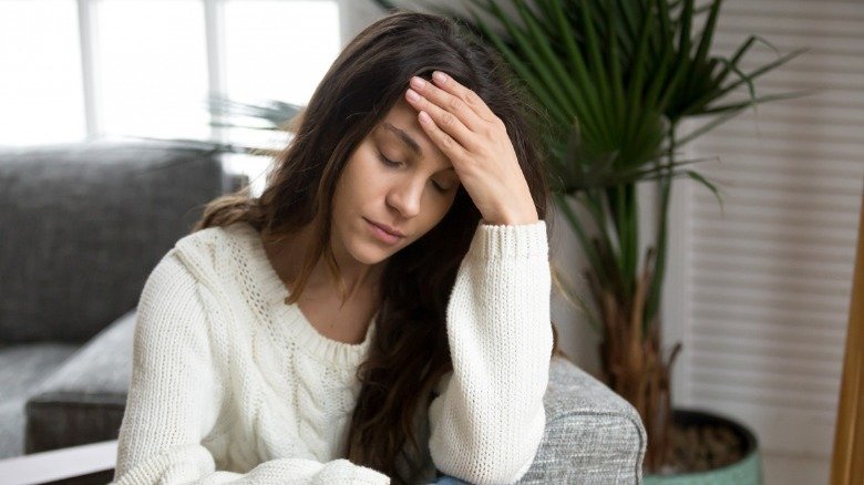 une femme assise se sent étourdie