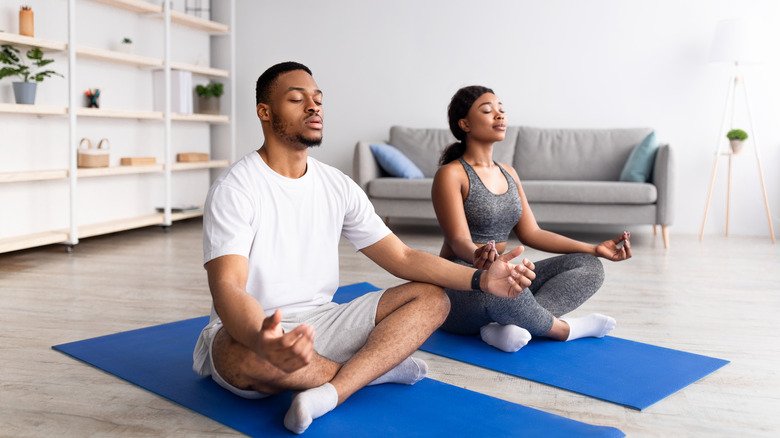 couple méditant sur un tapis de yoga