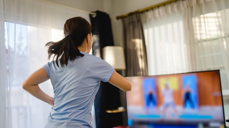 Femme faisant de l'exercice devant la télévision