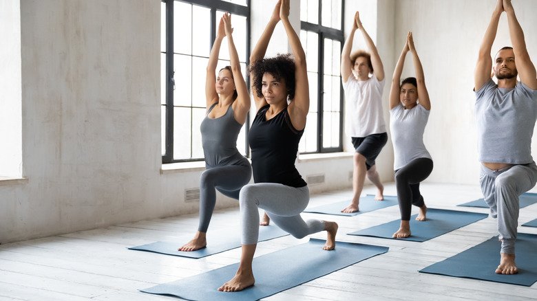 plusieurs personnes dans un cours de yoga