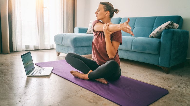 Femme s'étirant sur un tapis de yoga