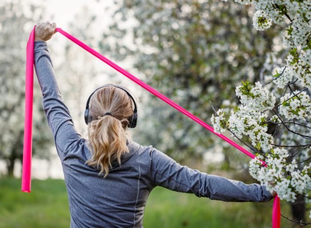 femme faisant des exercices avec des bandes de résistance à l'extérieur, concept d'entraînement avec des bandes de résistance pour rester actif et en forme en vieillissant