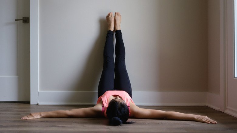 femme faisant la pose jambes contre le mur