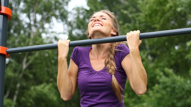 femme souriante faisant des tractions 