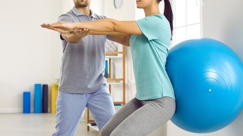 Femme faisant des squats avec ballon de stabilité