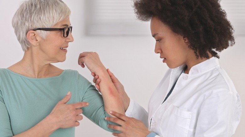 Un dermatologue examine le bras d'un patient