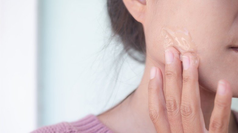 Femme frottant de l'aloe vera sur son visage