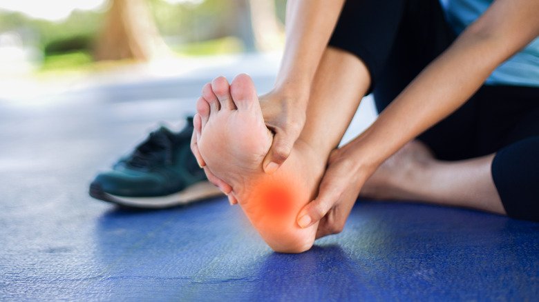 Une femme ressent une douleur sous le pied