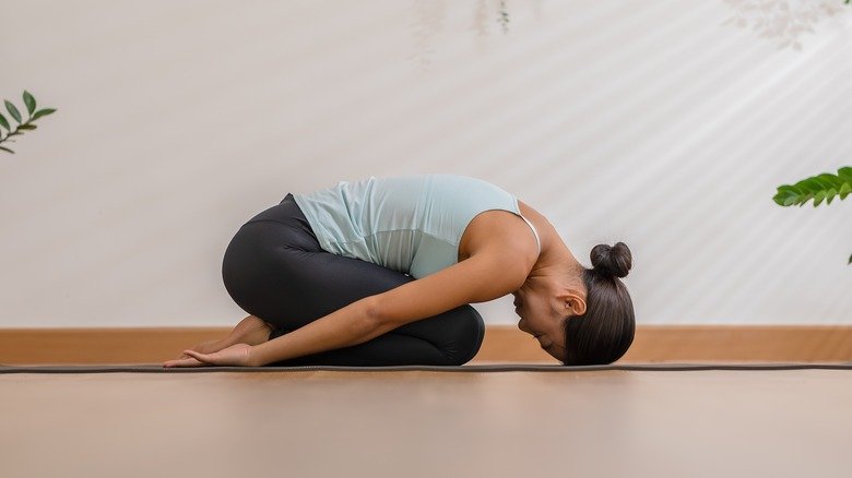 femme faisant la posture de l'enfant