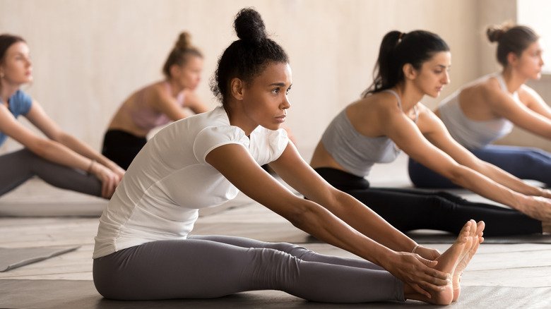 personnes faisant une flexion avant assise