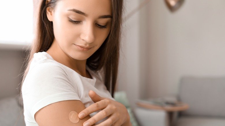 Une femme applique un patch à la nicotine sur son bras