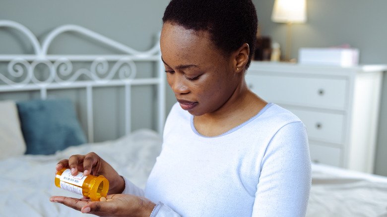 Une femme vide un médicament dans sa main