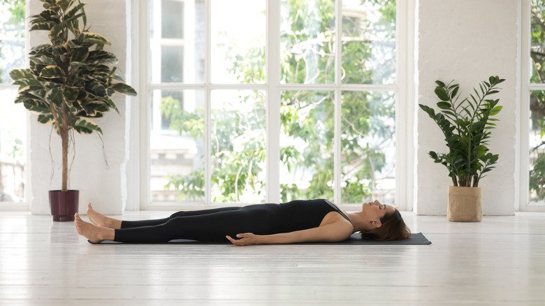 une femme pratiquant la posture du cadavre