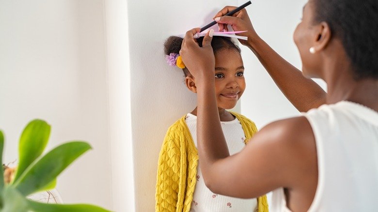 mère mesurant sa fille