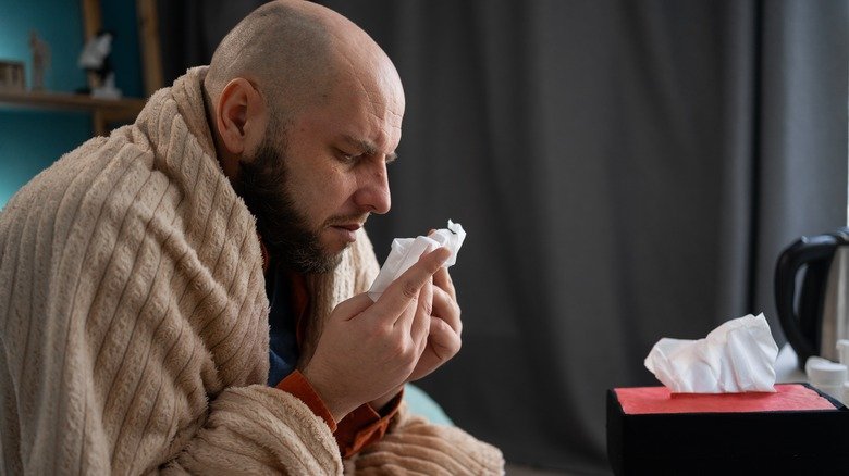 homme avec le nez bouché enveloppé dans une couverture