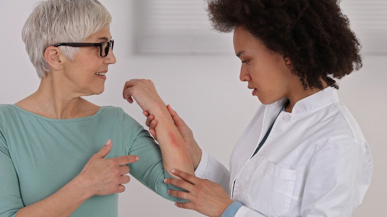 Médecin examinant l'éruption cutanée d'un patient