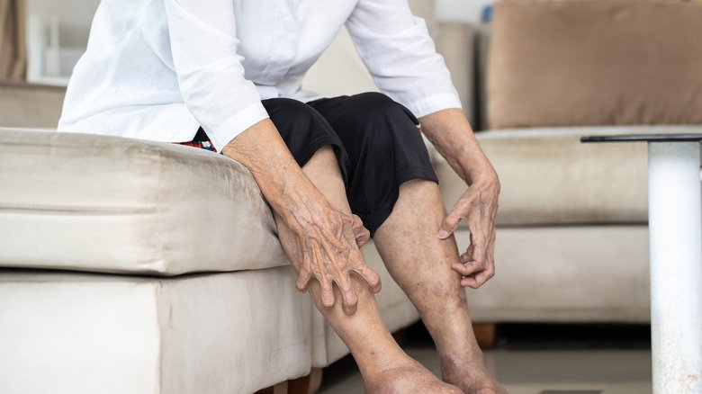 Personne âgée se grattant les jambes