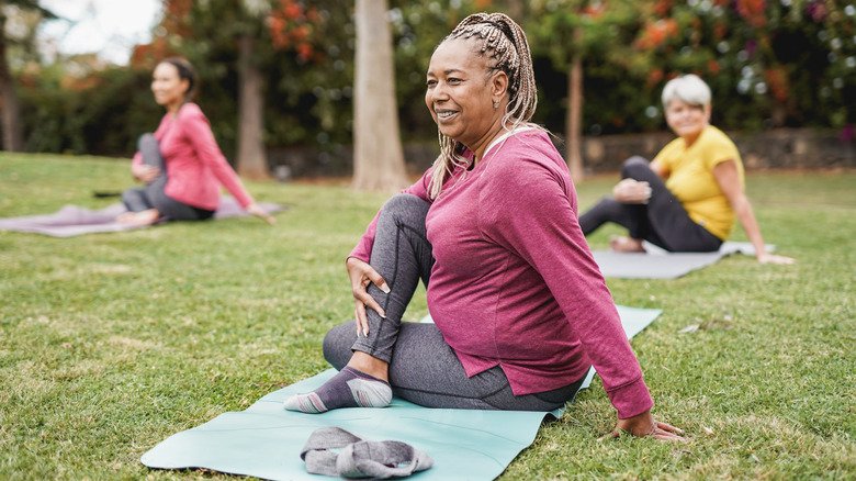 Femmes faisant du yoga dans un parc