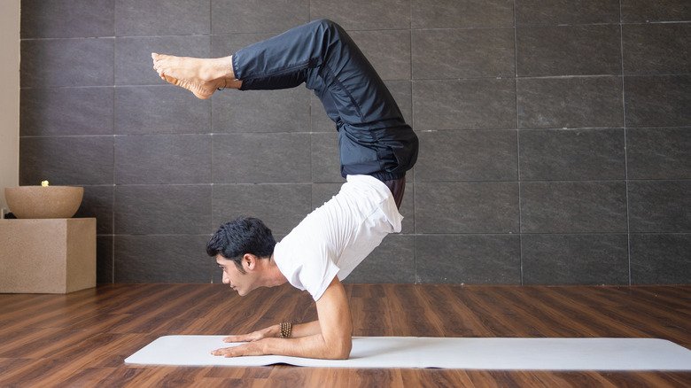 homme faisant la posture du scorpion