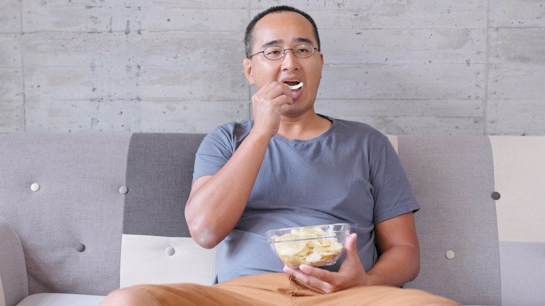 Homme mangeant un bol de chips