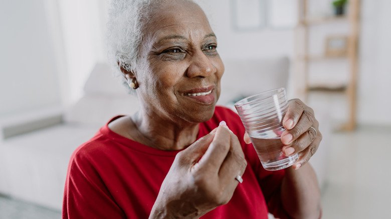 Femme souriante prenant des médicaments