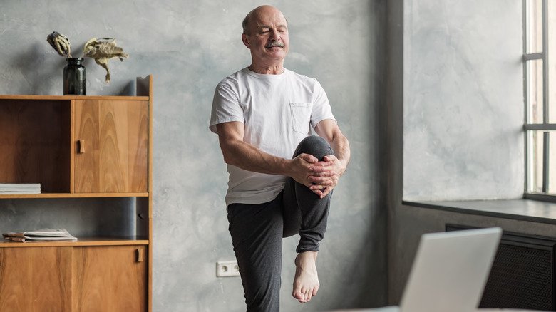 homme âgé en équilibre sur un pied