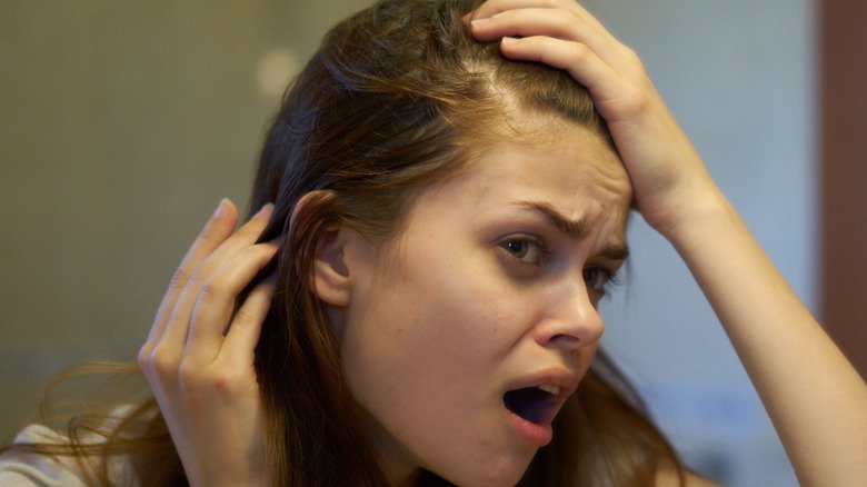 Fille examinant la racine des cheveux