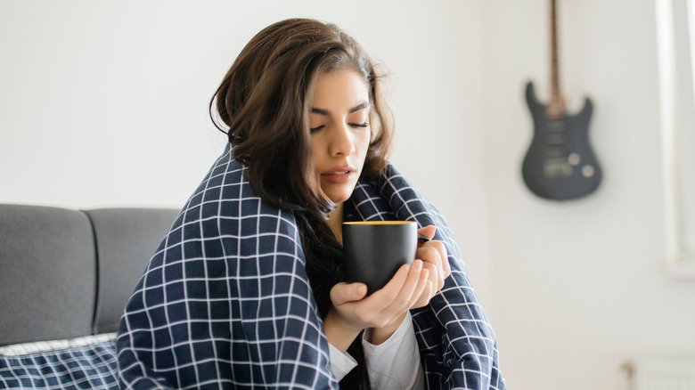 Une femme malade prend un café