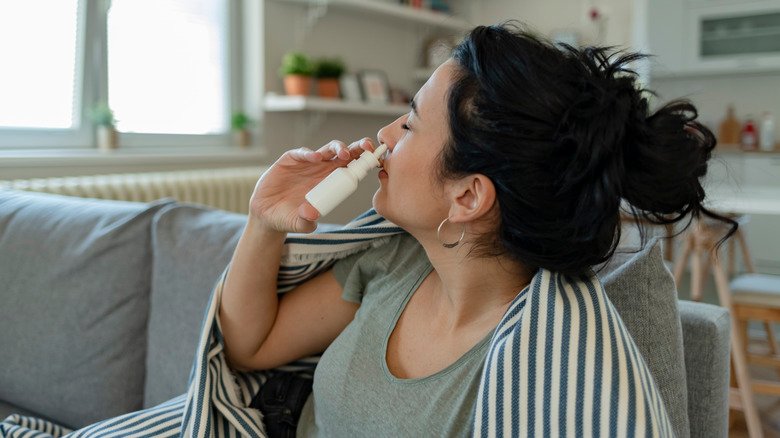 Femme utilisant un vaporisateur nasal