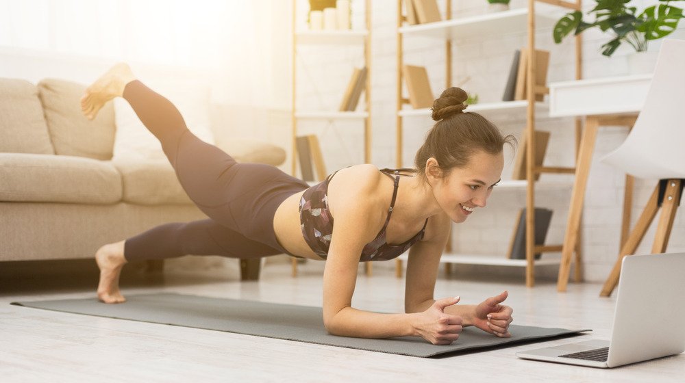 Femme regardant un ordinateur portable, faisant du yoga