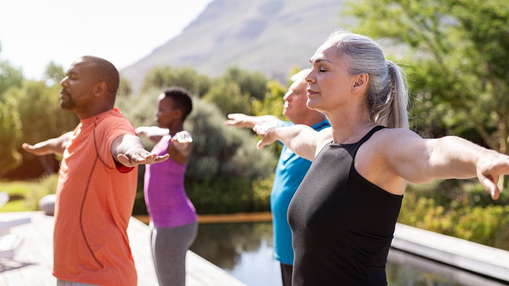 des gens qui font du yoga en plein air