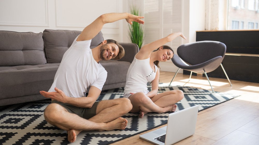 Couple faisant du yoga à la maison