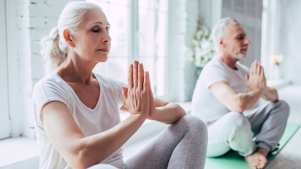 Couple de personnes âgées faisant du yoga