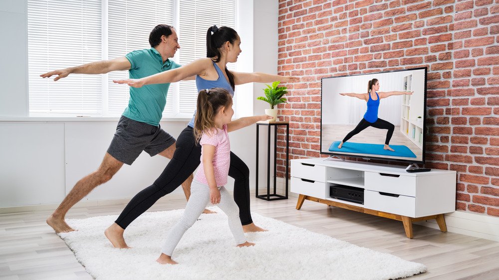 Famille faisant du yoga avec vidéo