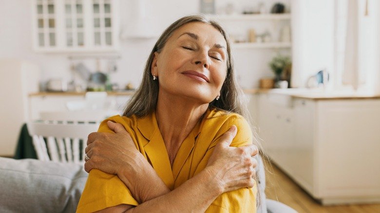 femme âgée souriante allongée dans son lit