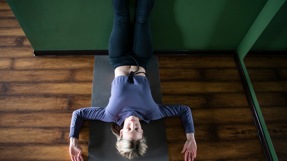 Femme faisant du yoga sur le sol