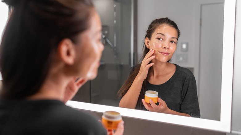 femme appliquant une crème hydratante