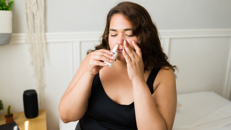 Femme utilisant un vaporisateur nasal contre les allergies