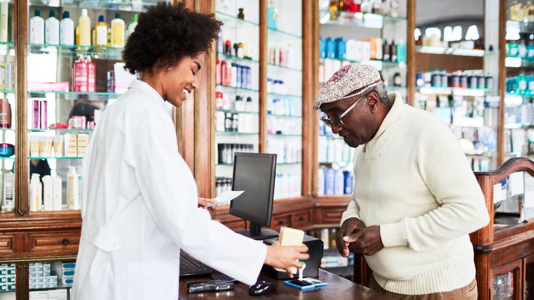 Un homme achète un produit dans une pharmacie