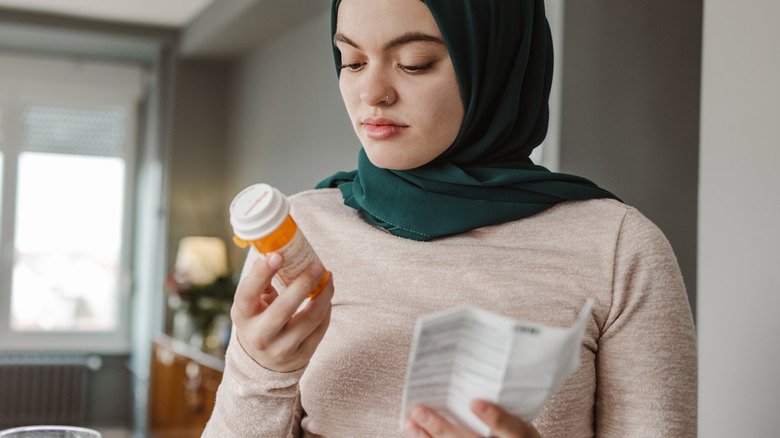 Femme lisant une étiquette de médicament sur ordonnance